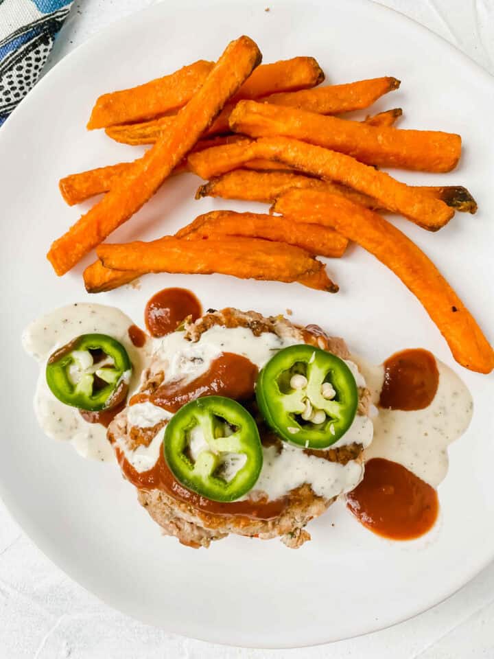 Side view of the Jalapeño Bacon Turkey Burgers on a white plate www.atwistedplate.com/jalapeno-bacon-turkey-burgers/